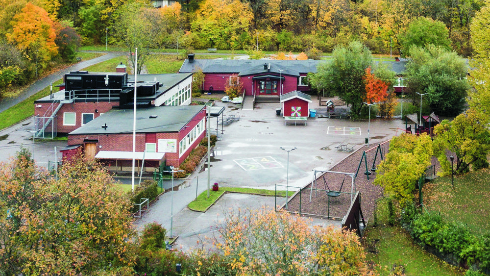 Bo skola. Ingång till röd träbyggnad med vimplar och ballonger