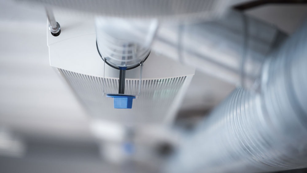 Farinet, Farsta. Ett rödfärgat flerfamiljshus med vita fönsterkarmar. med en lekstuga i förgrunden. 