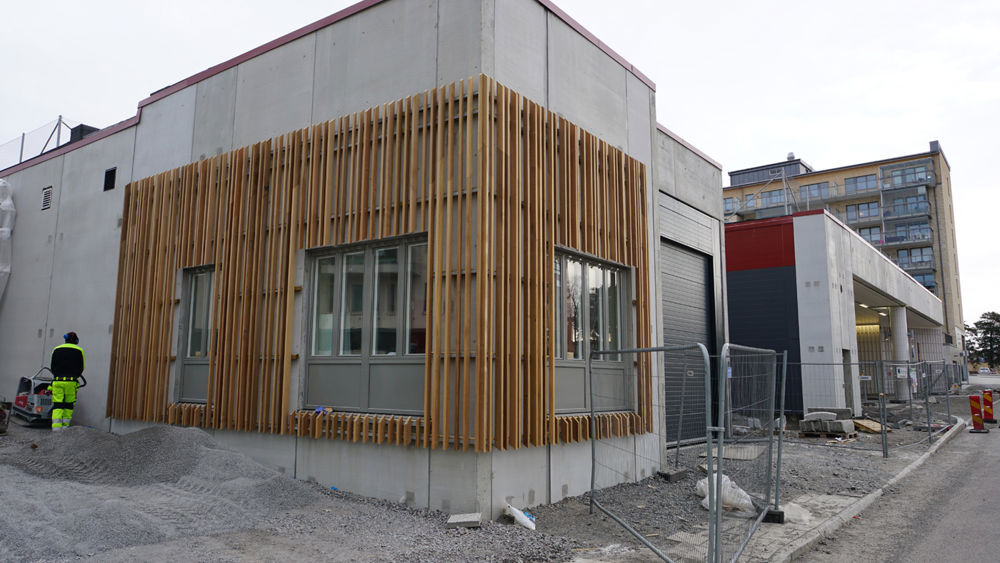 Haninge bussterminal. En envåningsbyggnad i trä och betong under byggnation. 