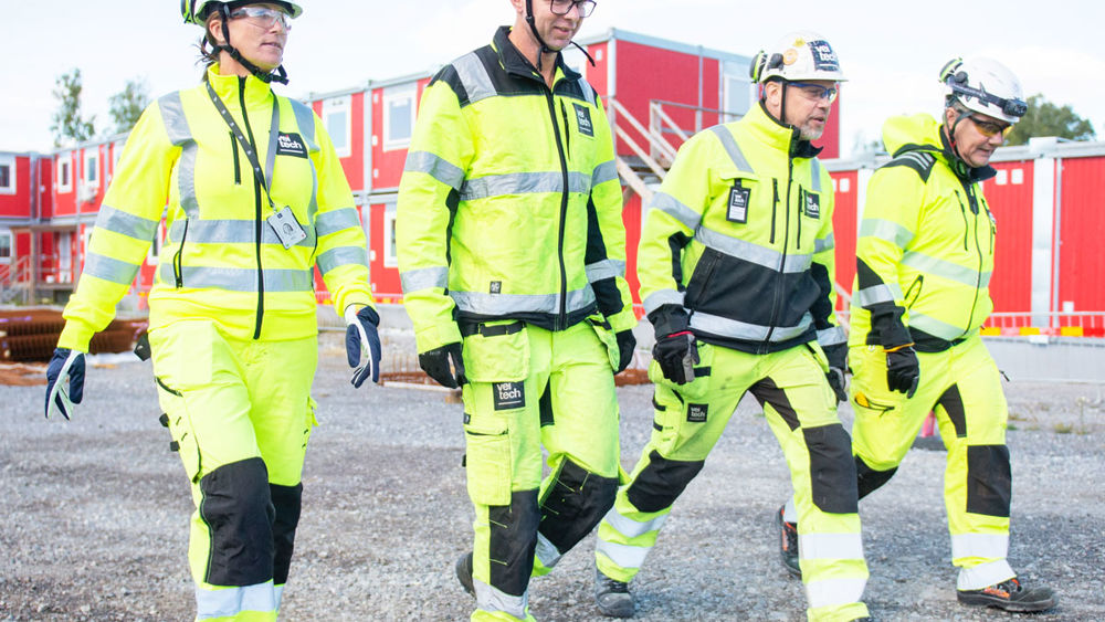 Fyra medarbetare på Veitech utomhus på en byggarbetsplats.