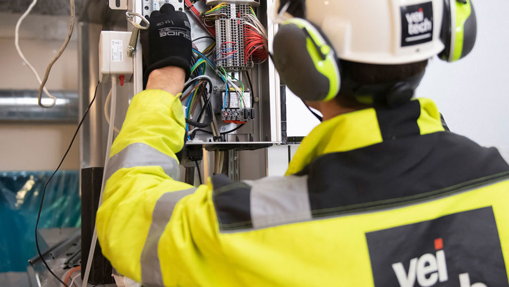 Person står och arbetar med ryggen mot kameran