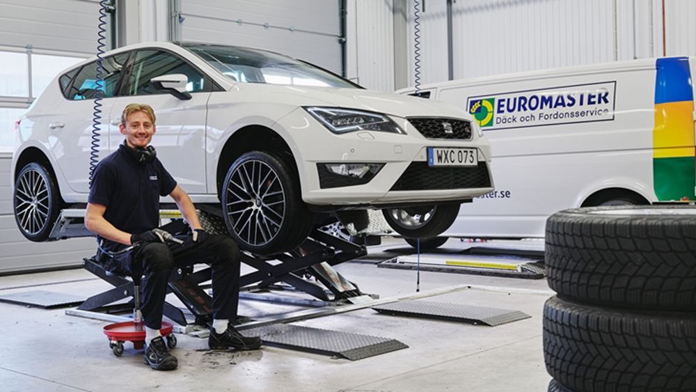 Euromaster. Inne på en bilverkstad med mekaniker som byter däck