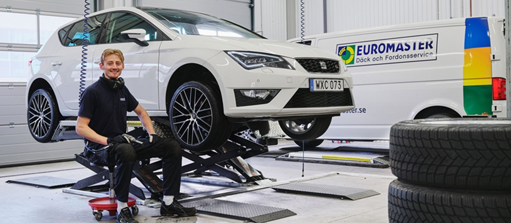 Euromaster. Inne på en bilverkstad med mekaniker som byter däck
